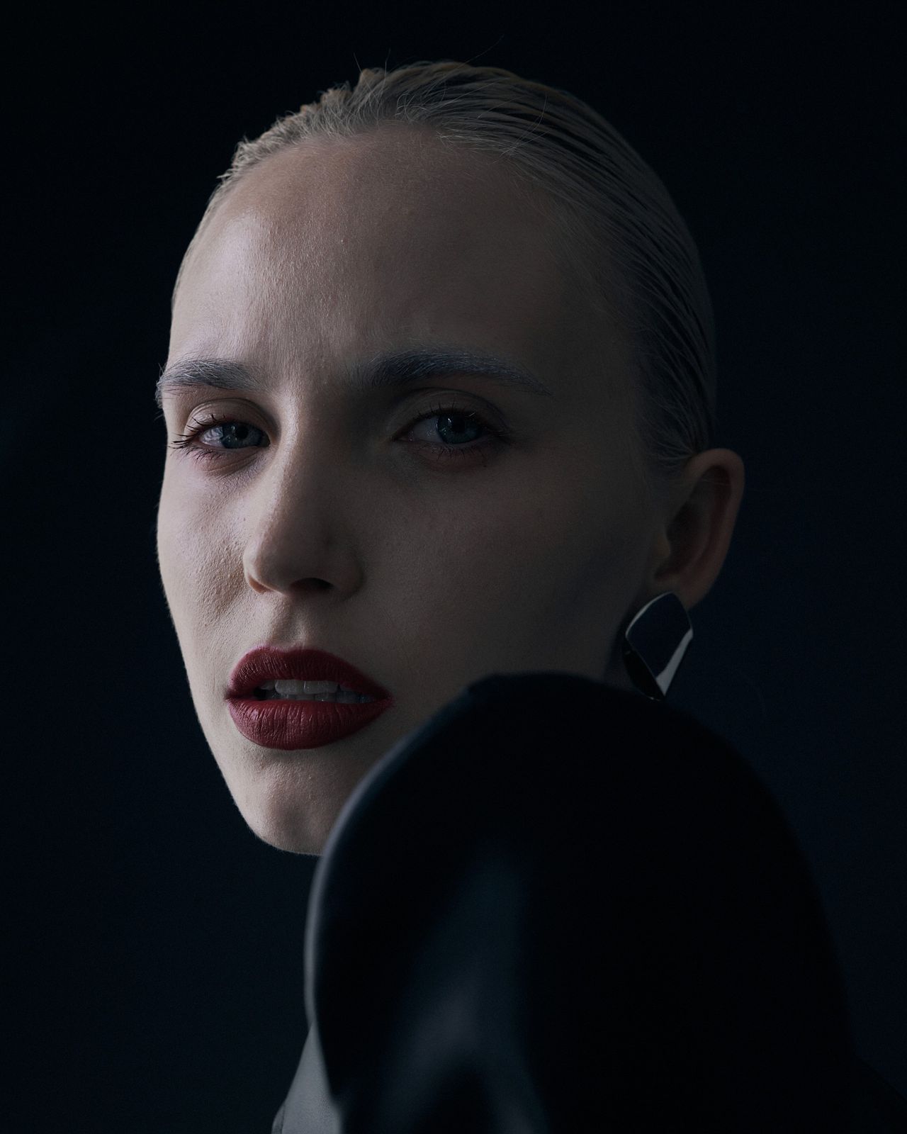 High fashion editorial close-up model with slicked hair red lips dark background — Thomas Habr fashion photographer