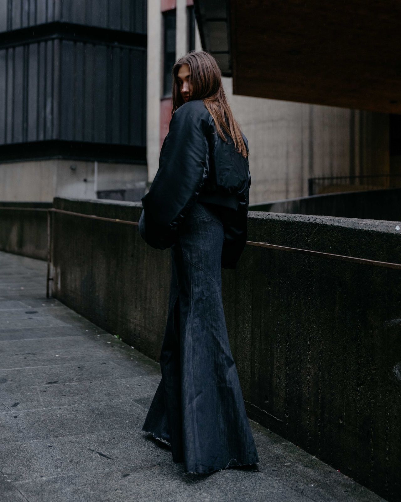 Urban editorial woman in long black trench coat architecture background — Thomas Habr fashion photographer