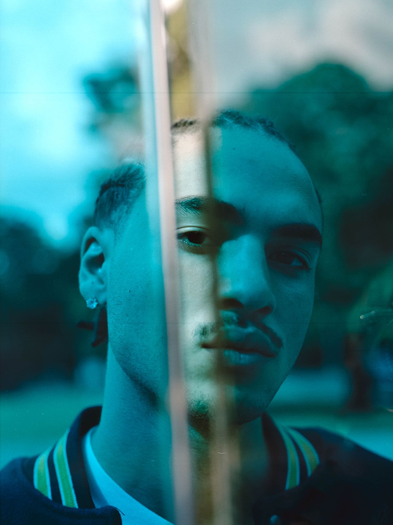 Moody cinematic portrait male model teal light leak — Thomas Habr music artist photographer Prague