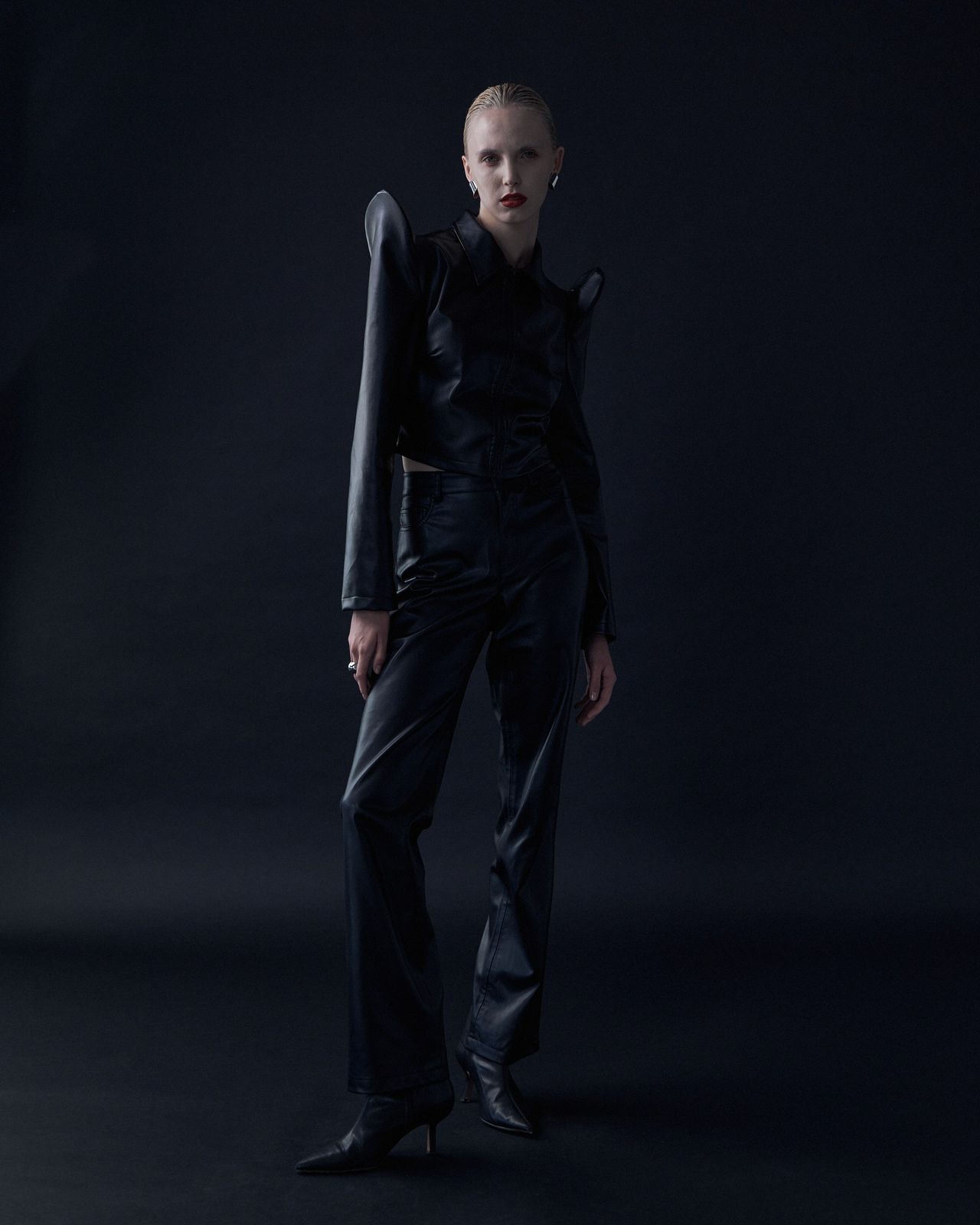 High fashion editorial full body model in black structured outfit dark studio — Thomas Habr photographer