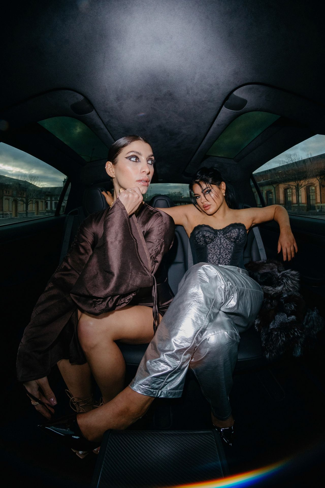 Fashion editorial two women posing inside car satin and metallic silver outfits — Thomas Habr fashion photographer